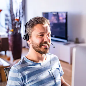 Mann arbeitet im Homeoffice mit Headset im Kundenservice