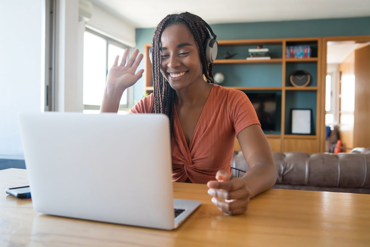 Freelancerin mit Headset bei einem Video-Call im Homeoffice