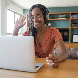 Freelancer wearing a headset during a video call from her home office