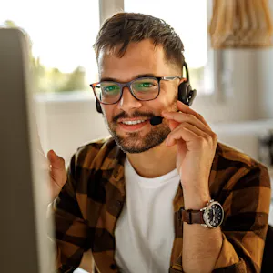 Man wearing a headset while working in customer service from home